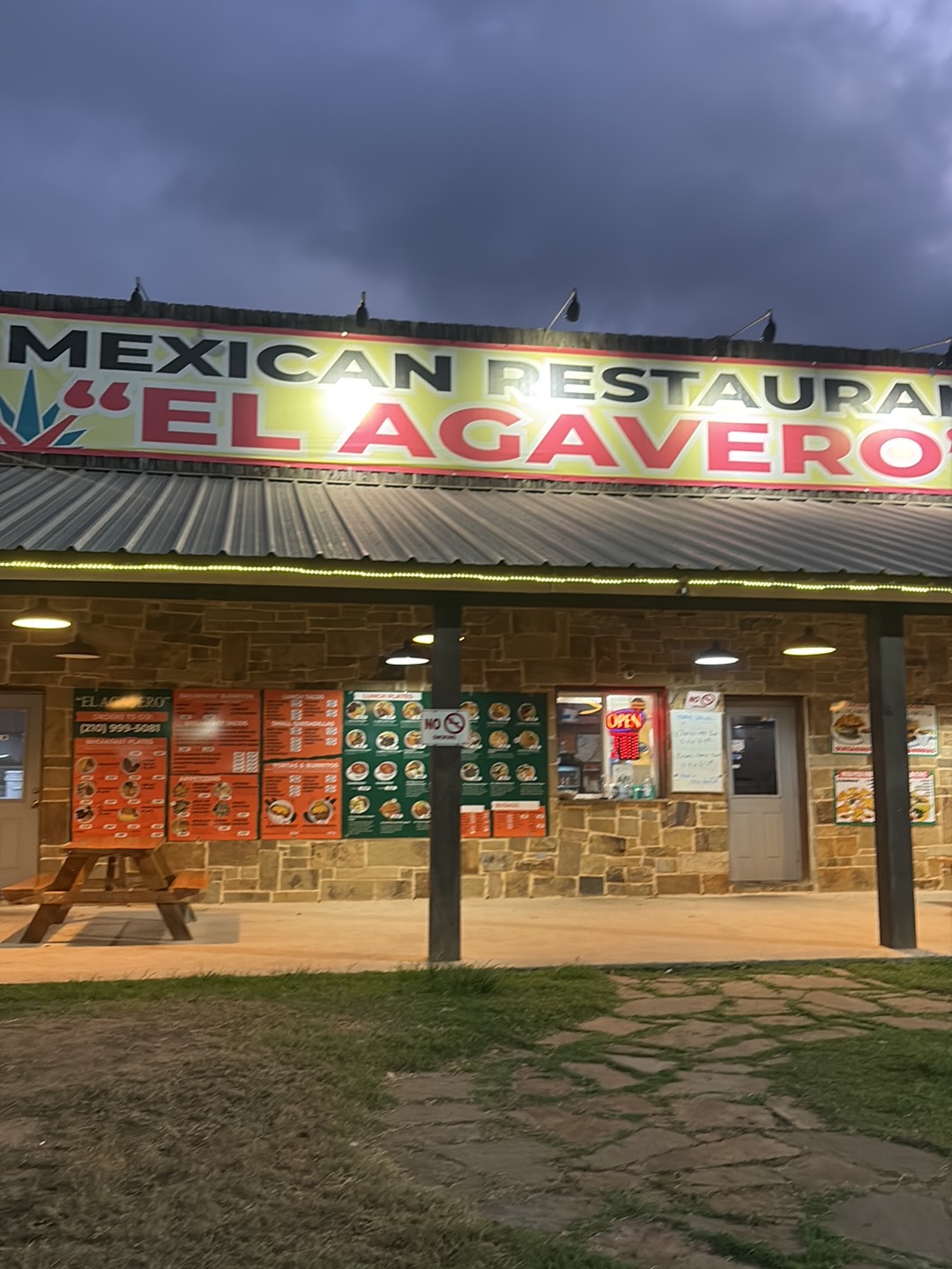 Tacos El Agavero exterior lit up at dusk with large Mexican Restaurant sign