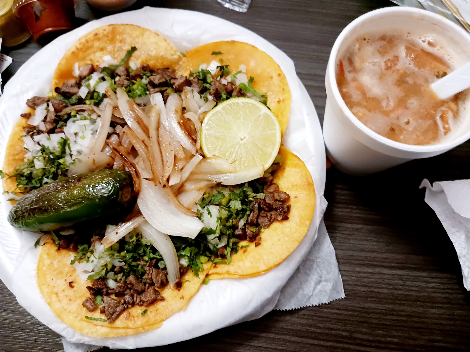 Street-style tacos with grilled onions, cilantro, jalapeño and a side of consomme
